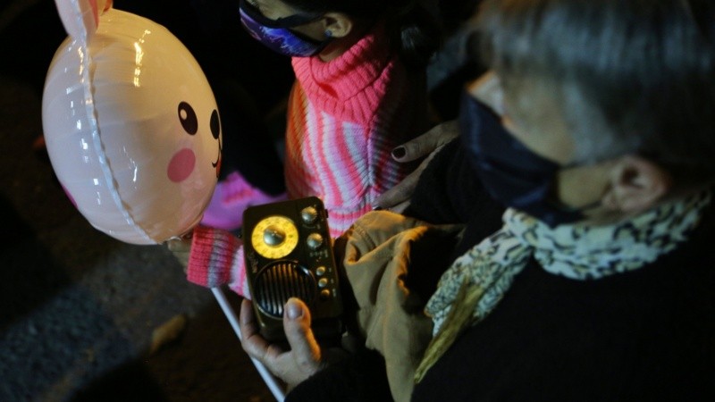 Muchos fieles con la radio en la mano en el Vía Crucis de barrio Rucci.