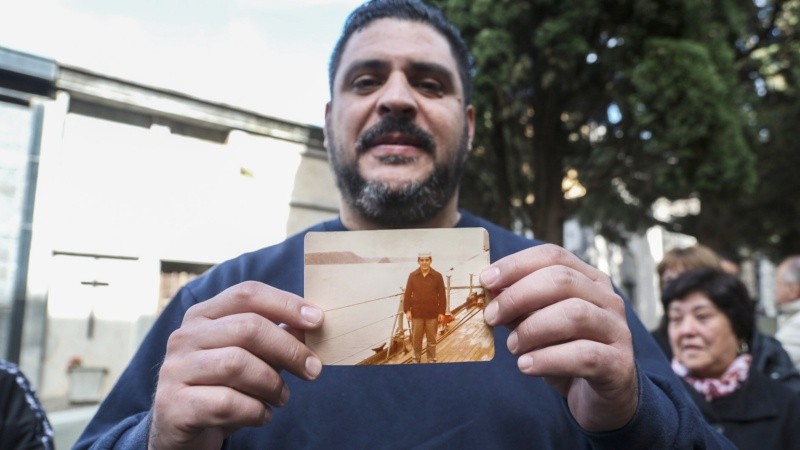 Santiago, hijo de Felipe Gallo, muestra una foto de su padre que le fue regalada por uno de los presentes.